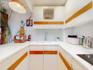 a kitchen with white cabinets and a sink at Pass the Keys Elegant flat in trendy Hampstead in London