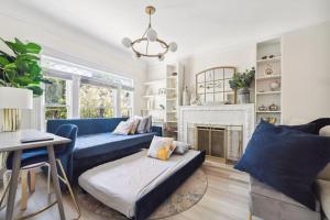 a living room with a blue couch and a fireplace at Luxury Retreat with Private Au Pair Suite in Oakland