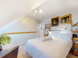 a bedroom with a large white bed with two towels at Pass the Keys Elegant flat in trendy Hampstead in London