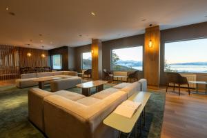 a living room with couches and tables and large windows at Los Acebos Ushuaia Hotel in Ushuaia +27 photos