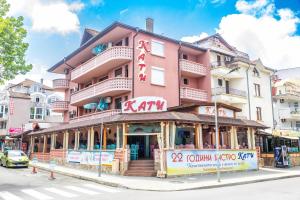 a pink building with a restaurant in front of it at Къща за гости КАТИ in Kiten