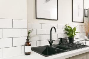 a kitchen counter with a sink and a bottle of wine at NEW LUXURY for 2024 - Central Plymouth House - Sleeps 10 - Access to Plymouth Town - Close to The Barbican - Pets welcome - Parking Available - By Luxe Living by Sophia in Plymouth +56 photos