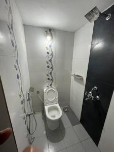 a small bathroom with a toilet and a shower at Flamingos villa in Varkala by bodhi garden in Varkala +12 photos