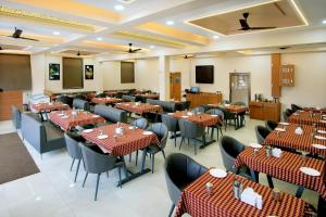 a restaurant with tables and chairs in a room at Hotel The Marion in Nashik