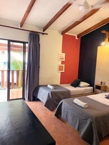 a bedroom with two beds and a balcony at Point Break Santa Teresa in Santa Teresa Beach