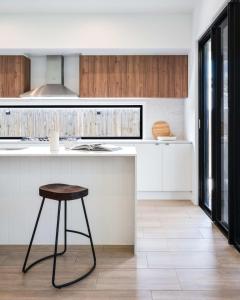 a kitchen with a counter and a stool in it at New Designer Built Boutique Holiday Home Heathwood in Doolandella +4 photos