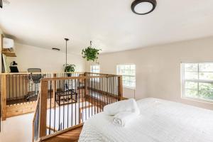 a bedroom with a bed in a room with windows at Cozy Coop Casita - Lake Travis-Hot Tub-Tiny House in Austin
