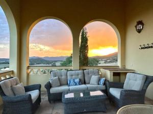 ein Wohnzimmer mit einer Couch und zwei Fenstern in der Unterkunft Finca La Alcolehuela en Parque Natural de Despeñaperros in Santa Elena