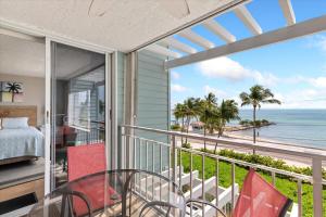 a bedroom with a balcony with a view of the ocean at Oceanfront Oasis in Key West