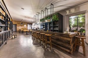 a restaurant with a wooden bar with wooden stools at Sapientia Boutique Hotel in Coimbra