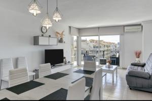 a living room with a couch and a tv at Apartamento con vistas a mar y canal. Empuriabrava in Empuriabrava