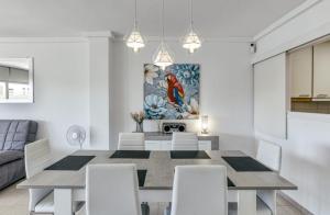 a white dining room with a table and chairs at Apartamento con vistas a mar y canal. Empuriabrava in Empuriabrava