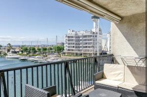 a balcony with a couch and a view of a marina at Apartamento con vistas a mar y canal. Empuriabrava in Empuriabrava