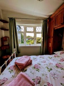 Un dormitorio con una cama grande con flores. en 2-Bed Bungalow Retreat, Welcombe, en Welcombe 31 fotos más
