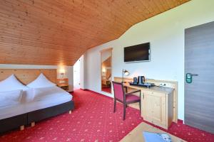 una camera d'albergo con un letto e una scrivania con un computer di Rothenfels Panorama Hotel a Immenstadt im Allgäu Altre 106 foto