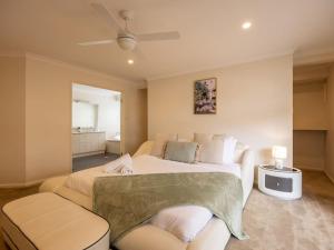 a bedroom with a large bed and a couch at Mins to Shop n Lake 4 beds family retreat with pool in Doolandella