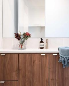 a kitchen counter with a vase of flowers on it at New Designer Built Boutique Holiday Home Heathwood in Doolandella