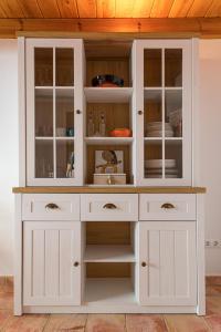 ein weißer Schrank mit Glastüren in einer Küche in der Unterkunft Casa rural La Artística, alojamiento y arte in Fuenteheridos