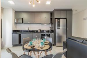 MHF II - Apts Variados em Prédio com Vista para o Mar em Itapema في ايتابيما: مطبخ وغرفة طعام مع طاولة وكراسي