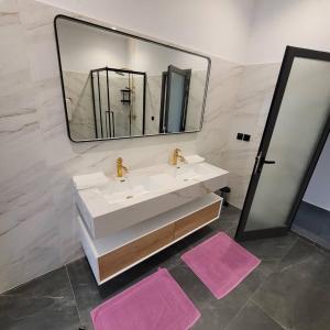 Sali TapéにあるHotel matyのバスルーム(シンク、鏡、ピンクのマット2枚付)