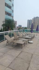 a row of benches with umbrellas on a building at Flat suite morador Hotel in Nova Iguaçu