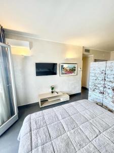 コゼンツァにあるSuite Roomsの大きなベッドとテレビのある寝室