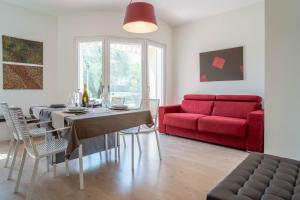 a living room with a table and a red couch at La casa di Bella - con Piscina in Padenghe sul Garda