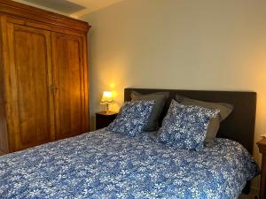 a bedroom with a bed with a blue blanket and pillows at Charming flat just outside Paris w free Private Parking in Saint-Ouen