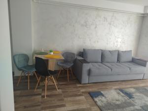 a living room with a couch and a table and chairs at Dimitra in Piatra Neamţ