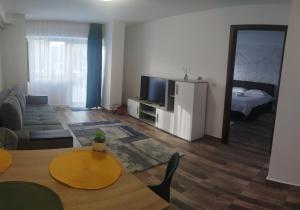 a living room with a table and a couch and a television at Dimitra in Piatra Neamţ