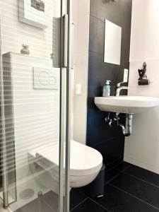 a bathroom with a toilet and a sink at Großzügige Wohnung - 6 Personen-3 Schlafzimmer- Parkplatz- Waschmaschine-2 Balkone in Wolfsburg +7 photos