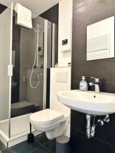 a bathroom with a sink and a toilet and a shower at Großzügige Wohnung - 6 Personen-3 Schlafzimmer- Parkplatz- Waschmaschine-2 Balkone in Wolfsburg