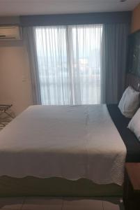 Postel nebo postele na pokoji v ubytování Flat com varanda, quarto de Morador Hotel 1112