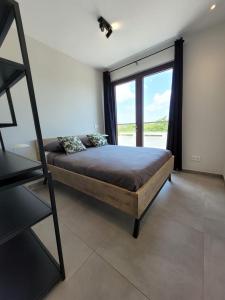 a bedroom with a bed and a large window at The Grand in Jan Thiel