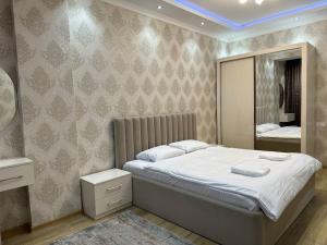 a bedroom with a large bed and a mirror at Dushanbe Place - Great Location in Dushanbe