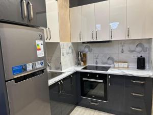 a kitchen with black and white cabinets and a sink at Dushanbe Place - Great Location in Dushanbe +1 photo