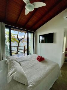 伊利亚贝拉Casas do Mar的一间卧室配有一张白色床,上面有红花