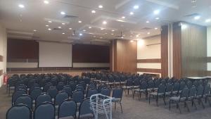 a conference room with chairs and a white screen at Flat em hotel Morador 106 in Nova Iguaçu