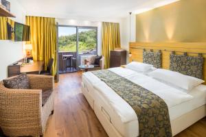 a bedroom with a large bed and a living room at Hotel Heiligenstein in Baden-Baden