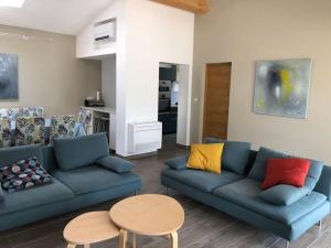 ein Wohnzimmer mit einem blauen Sofa und einem Tisch in der Unterkunft Villa MAJOULIÈRE in La Ciotat