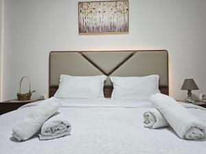 a bedroom with a white bed with towels on it at Superb 1 bedroom in the best zone of the city. in Ferizaj