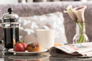 a table with a plate of strawberries and a cup of coffee at The Ritz-Carlton Atlanta in Atlanta