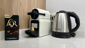 eine schwarz-weiße Kaffeemaschine und eine Schachtel auf einer Theke in der Unterkunft Playa mar by Gloove in San Juan de los Terreros