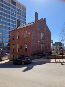 a car parked in front of a brick building at Chipman Hill Suites -Yeats House in Saint John