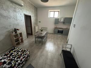 a living room with a table and a kitchen at Appartamento Verde MilliGio primo piano in Marigliano