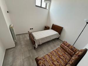 a small bedroom with a bed and a couch at Appartamento Verde MilliGio primo piano in Marigliano