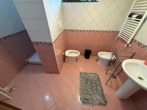 a pink bathroom with a toilet and a sink at Appartamento Verde MilliGio primo piano in Marigliano