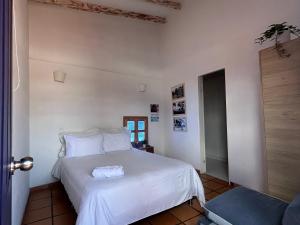 a bedroom with a large white bed with white sheets at Zana Hotel Boutique in Bogotá
