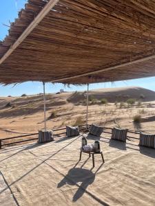 a patio with two chairs and a table in the desert at Mirage Desert Camp in Al Raka