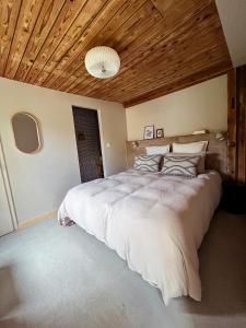 a bedroom with a large bed with a wooden ceiling at Grange ALMA in Obernai